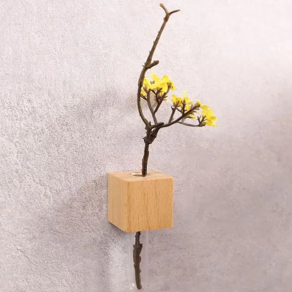 DecorBites wooden magnetic test tube vase with a minimalist wooden cube and clear glass tube vase holding yellow flowers