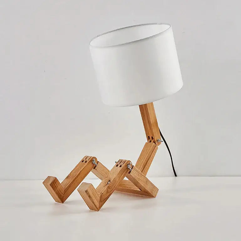 Minimalist wooden robot shape table lamp with white cylindrical shade and articulated legs for indoor study lighting