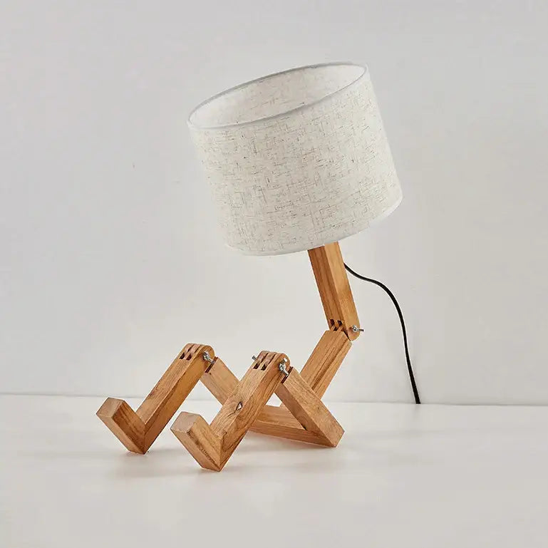 Decorbites wooden robot shape creative table lamp with beige fabric shade and articulated wooden legs for indoor use