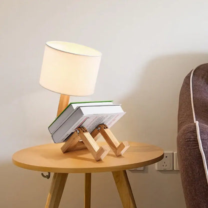 Light wood book stand with minimalist design supporting two stacked books beneath angled legs for decorbites wooden robot shape lamp
