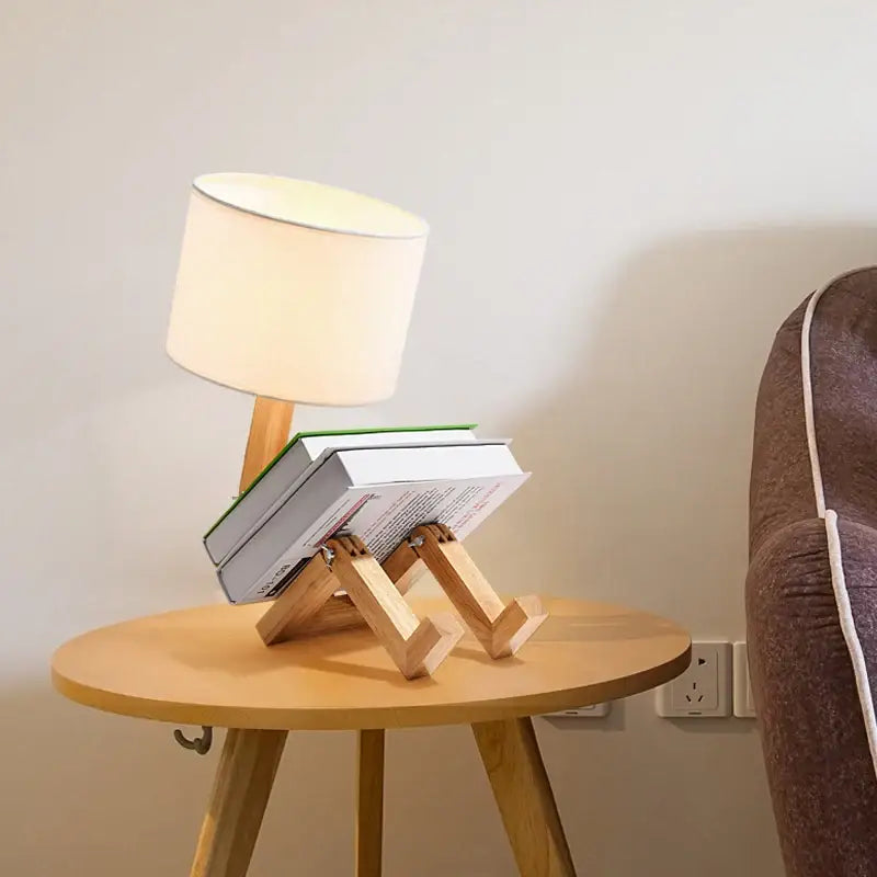 Light wood book stand with minimalist design supporting two stacked books beneath angled legs for decorbites wooden robot shape lamp