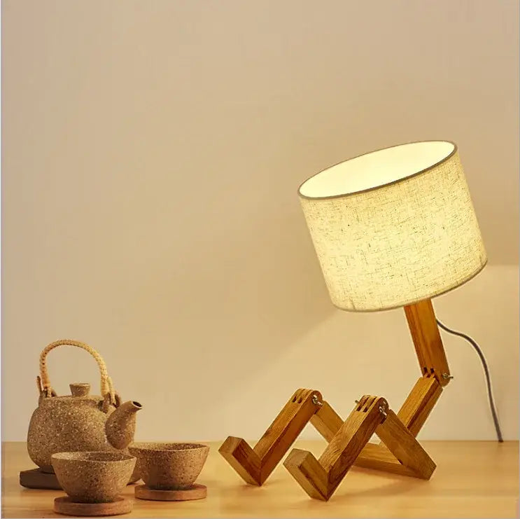 A warm-toned fabric lampshade on a wooden robot shape creative stand in nordic modern style for indoor study lighting