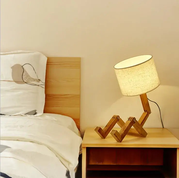 DecorBites wooden robot shape table lamp with warm wood, beige fabric shade, and articulated jointed legs for indoor use