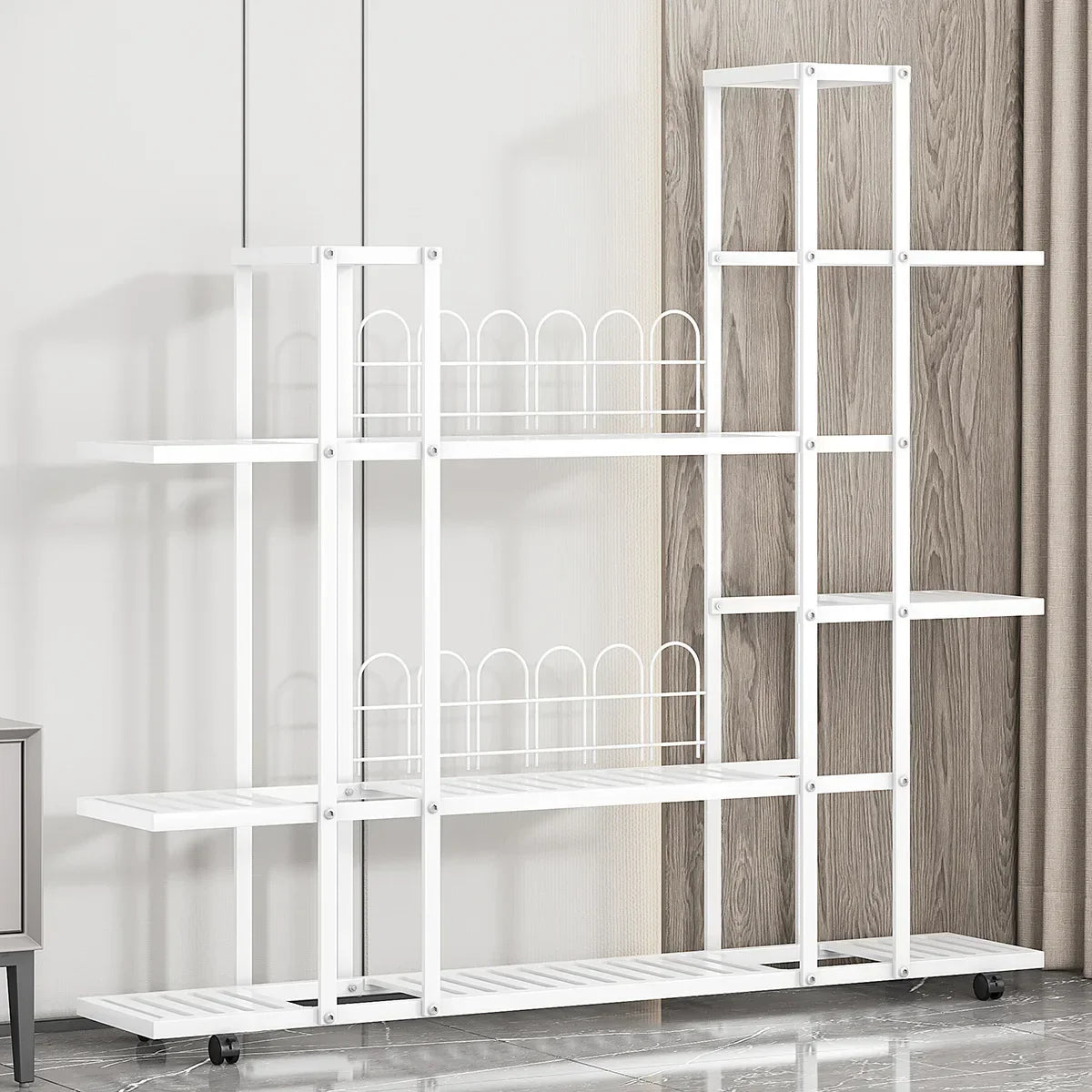 White wrought iron plant stand with multiple shelves and decorative arched wire dividers on wheels by decorbites