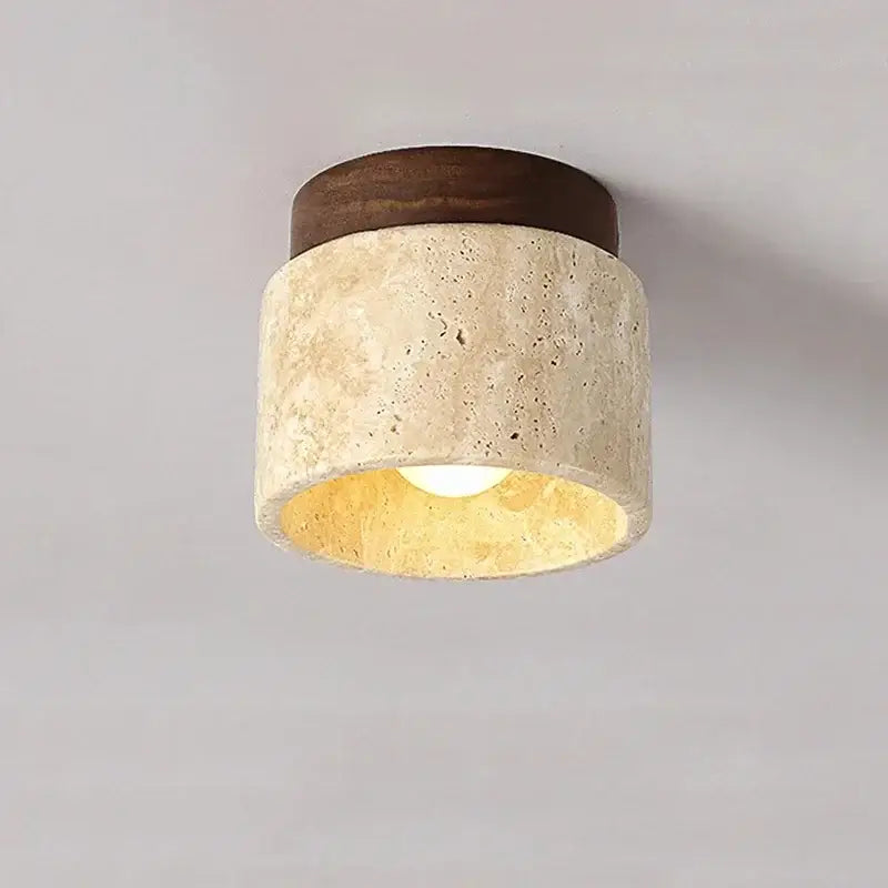 Rounded ceiling light with textured beige stone body and dark wood top emitting warm glow for home or commercial use