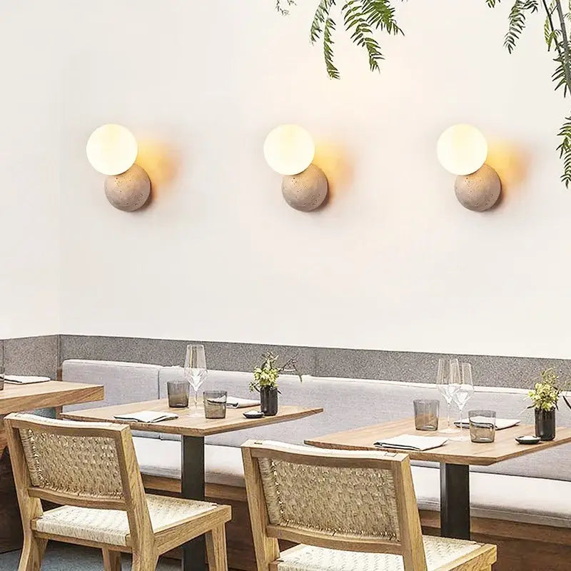 Three identical modern yellow travertine wall sconces with frosted glass globes on concrete bases for bedroom decorbites yellow travertine