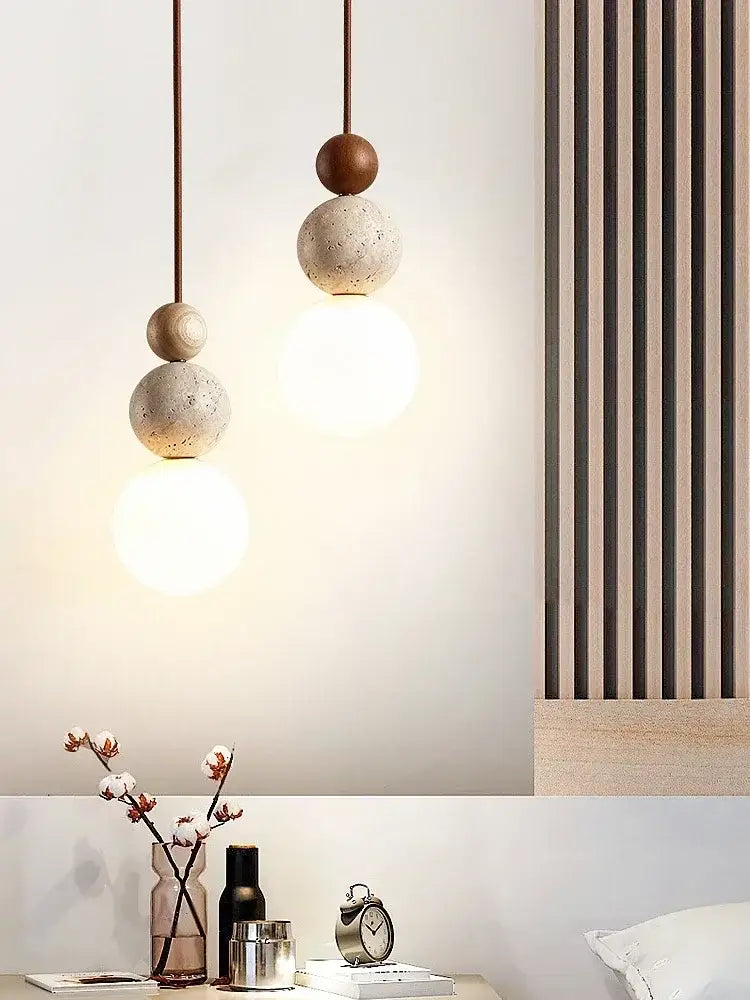 DecorBites™ yellow travertine pendant light featuring stacked spherical stone pendant with bronze accents and warm bulbs