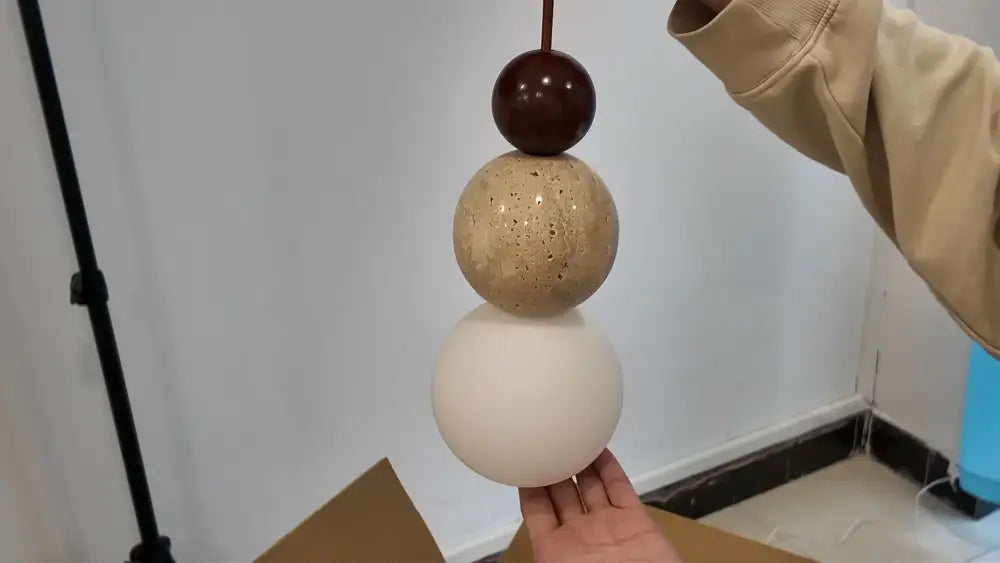 Decorbites™ yellow travertine pendant light with dark brown, speckled beige, and matte white stone pendant beads
