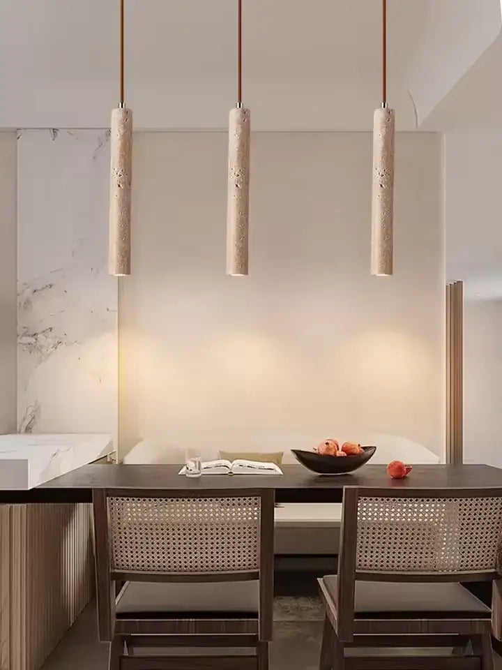 Three beige decorbites™ yellow travertine stone pendant lights with textured finish hang above kitchen island