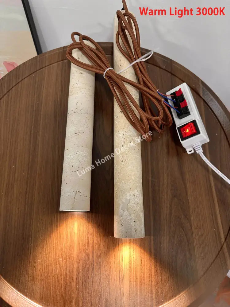 Two yellow travertine stone pendant lights with warm white 3000k glow and brown braided cords for kitchen island