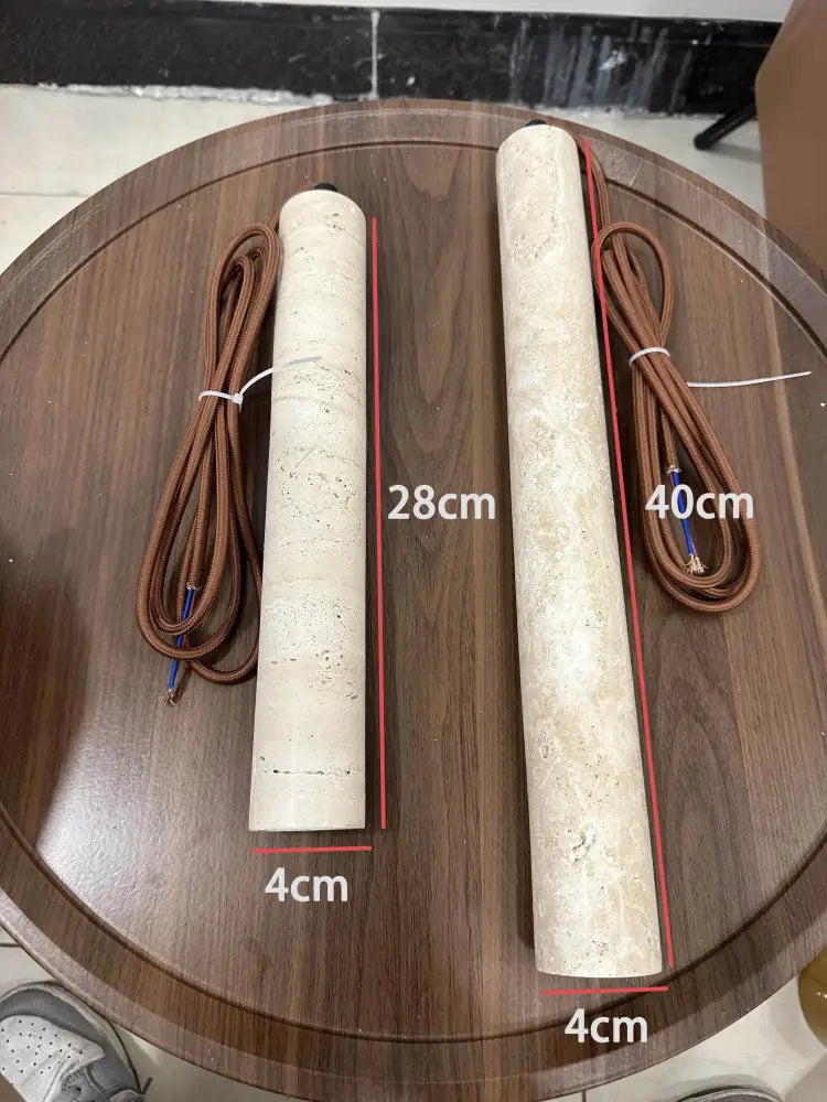 Two beige textured cylindrical heating elements with brown braided cords for decorbites stone pendant light