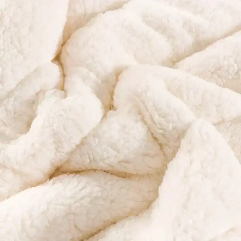 Cream-colored plush fleece blanket with soft textured surface complementing deep blue and white cozy flannel fleece quilt