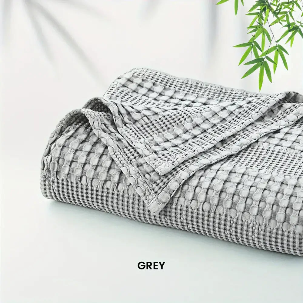 Deep blue bamboo cotton waffle blanket with soft textured grey cotton waffle weave for lightweight cozy decorbites use