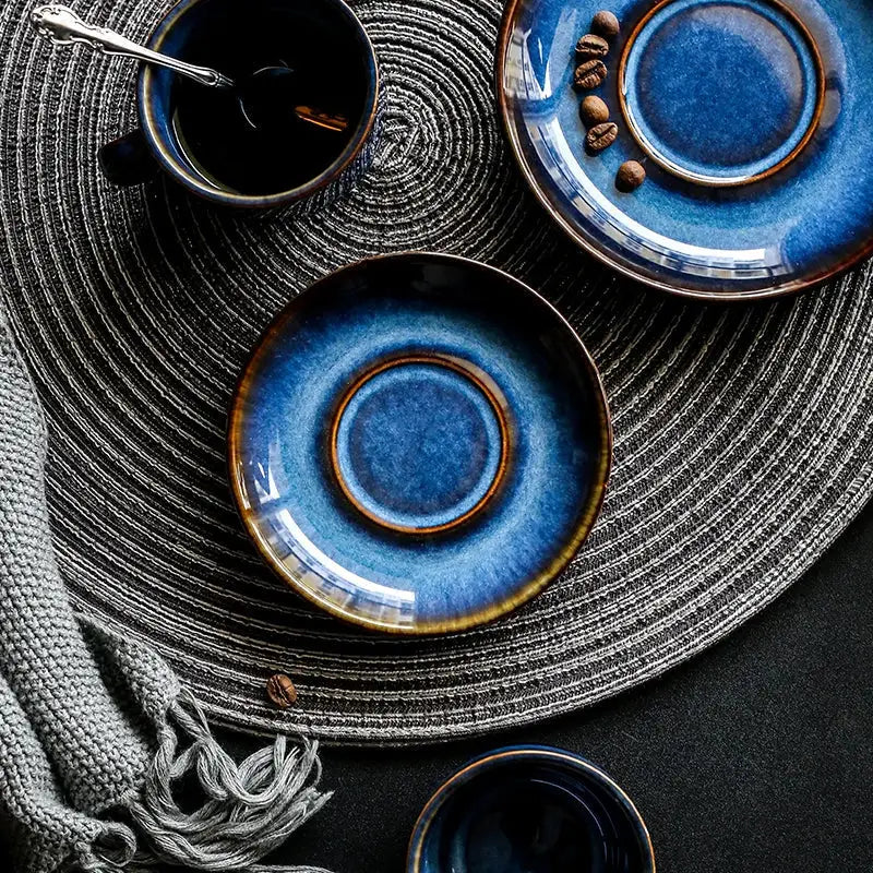 Deep blue glossy ceramic coffee cup saucer with brown rim, part of an espresso coffee cup saucer set for dining room