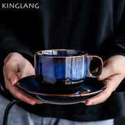 Deep blue glossy ceramic espresso coffee cup with subtle vertical striations on matching coffee cup saucer set