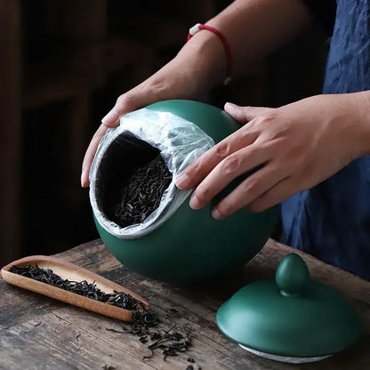 Matte deep green ceramic tea caddy jar with rounded body and smooth surface for kitchen storage