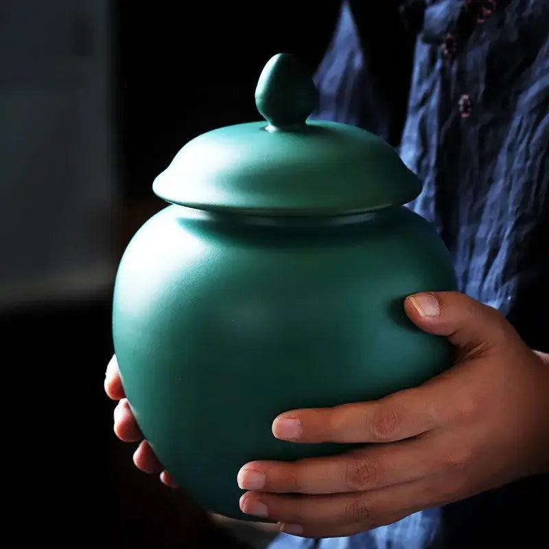 Deep green ceramic tea caddy jar with smooth matte finish and matching lid for kitchen storage container use