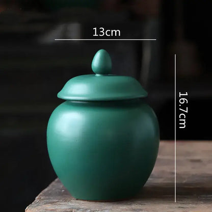 Deep green ceramic tea caddy jar with smooth matte finish and egg-shaped knob for kitchen storage