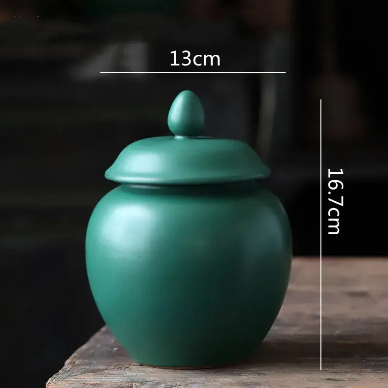Deep green ceramic tea caddy jar with smooth matte finish and egg-shaped knob for kitchen storage