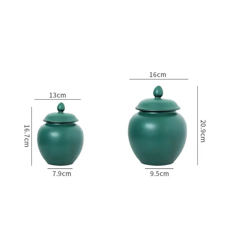 Two matte deep green ceramic tea caddy jars with rounded bodies and matching lids for kitchen storage