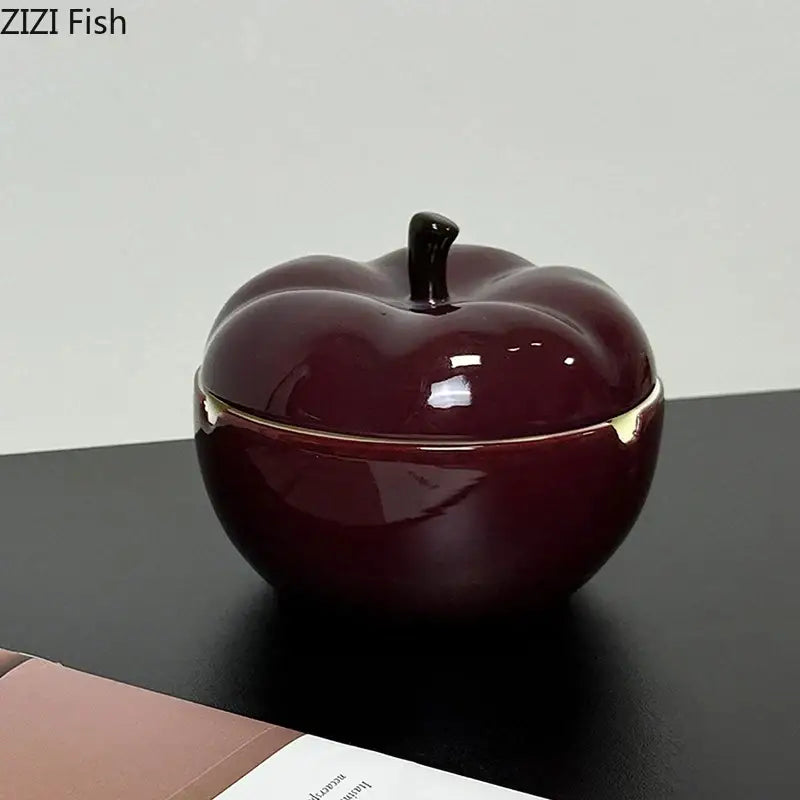 A deep red ceramic apple ashtray with lid featuring a glossy finish black stem and gold-trimmed edges for decorbites decor