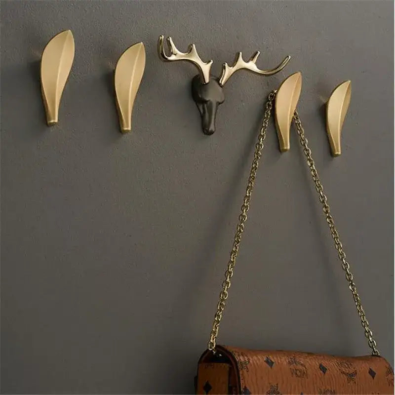 Deer antler gold brass wall mount robe hooks with gold-toned leaf design and matte black antler centerpiece decorbites brass wall