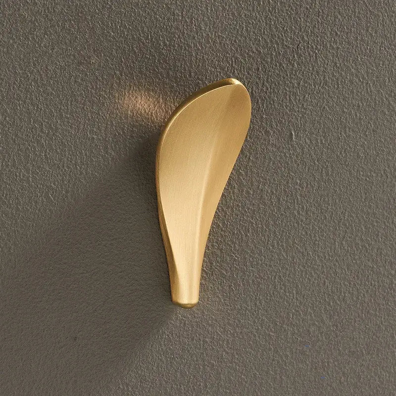A sleek brushed gold brass wall mount robe hook shaped like a leaf for modern bathroom decorbites brass wall use