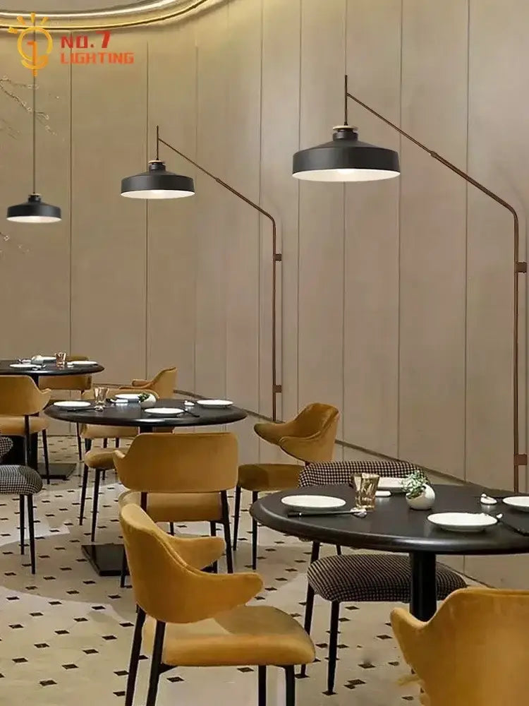 Black pendant lamps with curved metal arms cast warm light complementing decorbites gold black swing wall lamp design