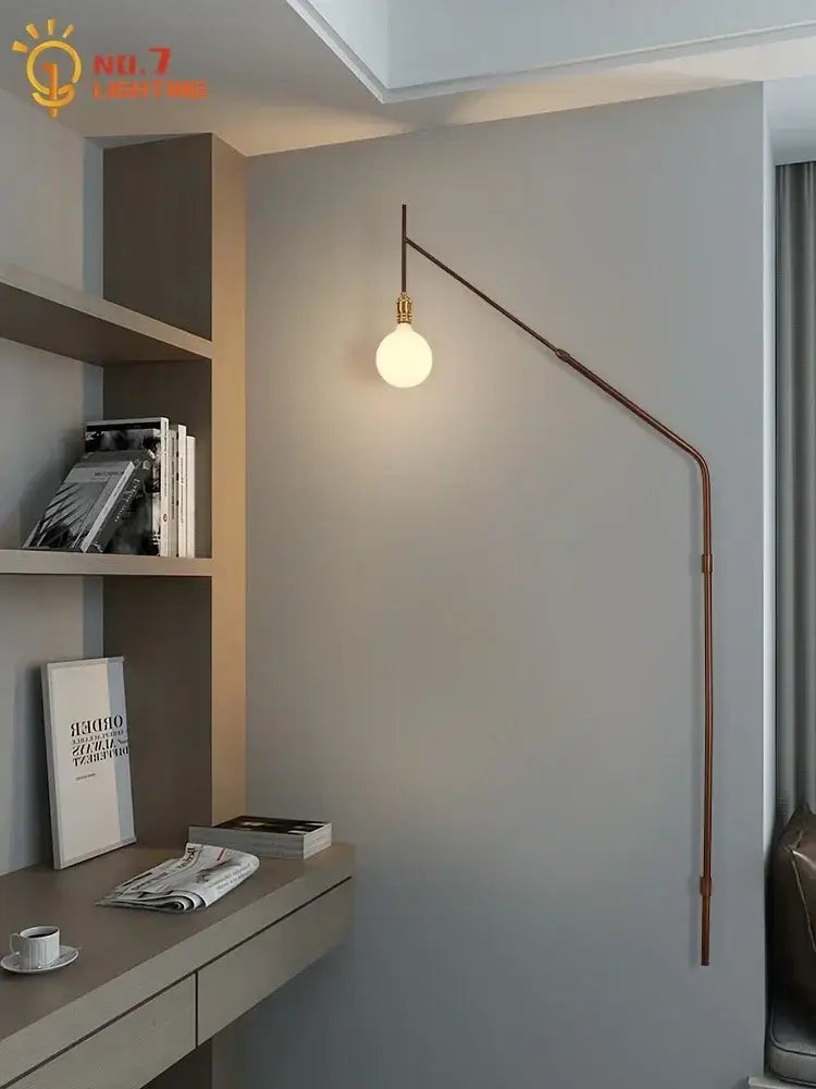 A sleek copper wall lamp with a warm glowing bulb for bedroom reading light featuring gold black swing arm design