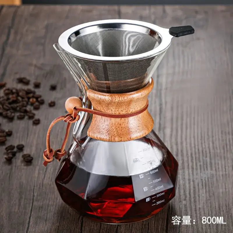 A sleek diamond glass hand brew coffee maker with wooden collar stainless steel filter and leather strap for kitchen use
