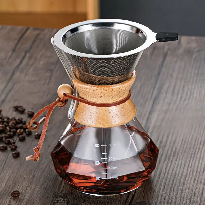 A clear glass hand brew coffee chemex with wooden collar stainless steel filter and brown leather tie for kitchen dining