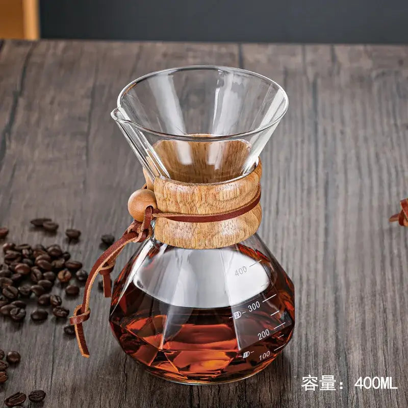 Clear glass diamond glass hand brew coffee maker with wooden collar and amber brewed coffee for kitchen dining