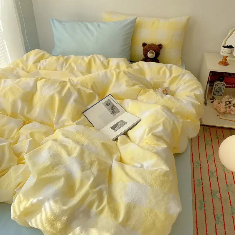 Soft yellow and white checkered diamond jacquard duvet cover with a plush teddy bear in cream bedroom setting