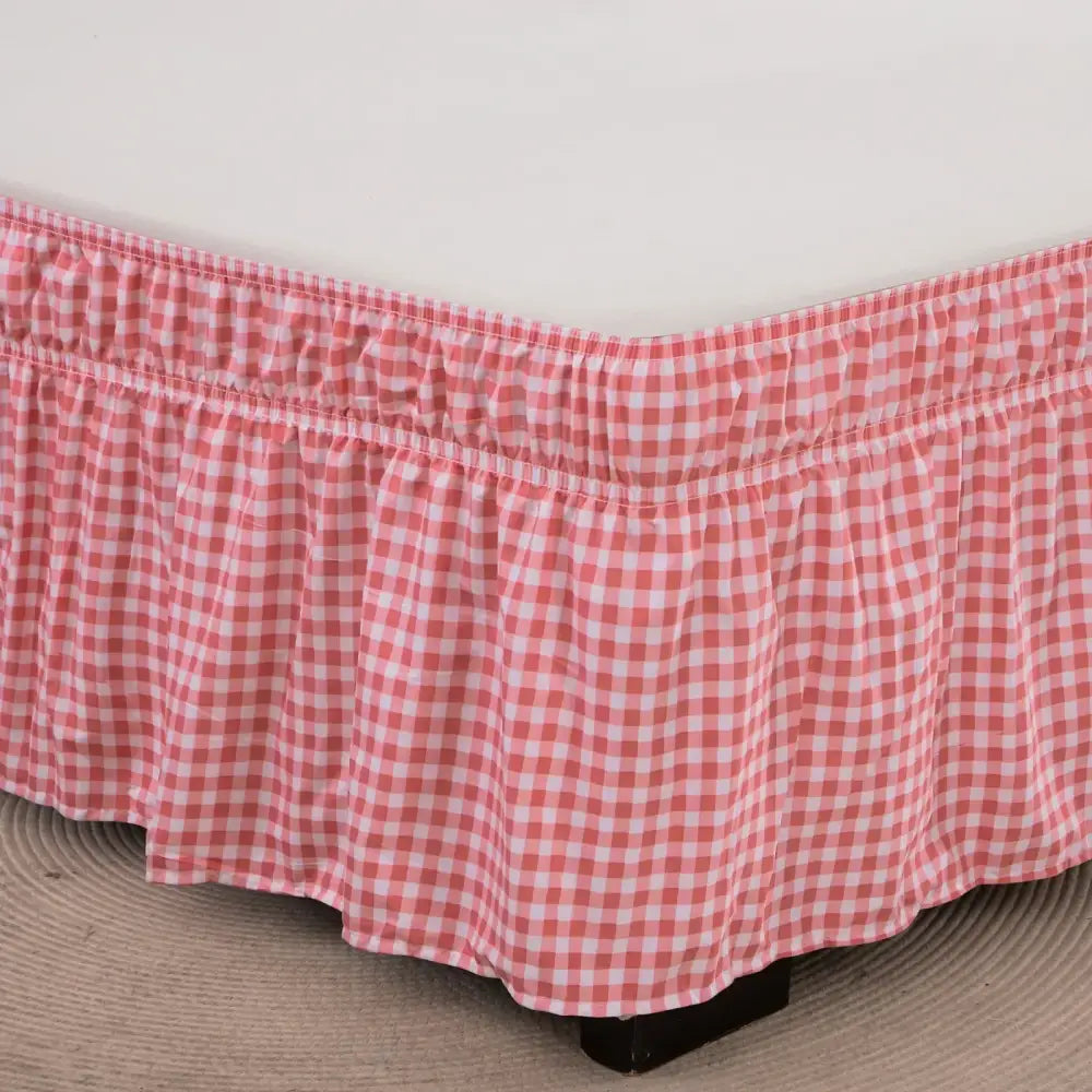 Pink and white gingham bed skirt with ruffled hem featuring diamond lattice ruffled design and elastic band closure