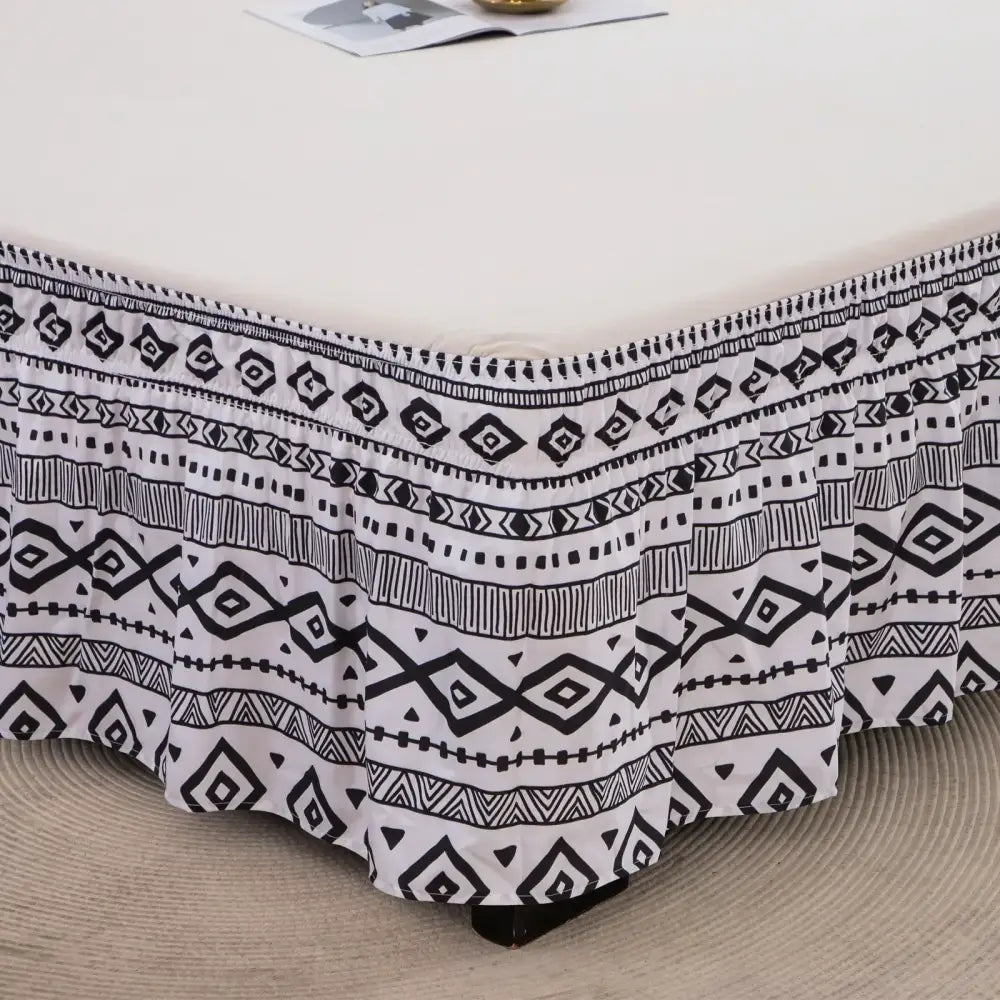 Diamond lattice ruffled black and white bed skirt with elastic band and geometric pattern featuring a ruffled hem