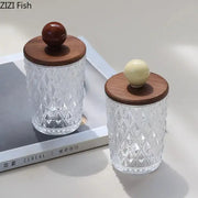 Clear glass jars with diamond-cut pattern and walnut lids featuring dark brown and cream colorful ceramic ball knobs for bedroom storage