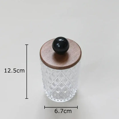 Clear glass jewelry jar with diamond pattern and walnut lid topped by glossy black colorful ceramic ball knob for storage