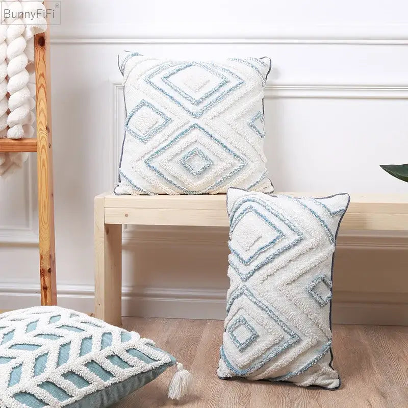 Cream-colored cushion cover with diamond tufted blue and white textured geometric patterns and tassels for living room