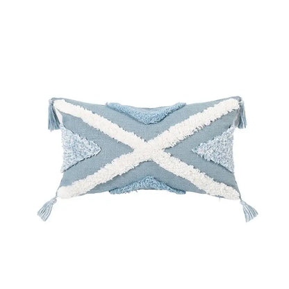 Light blue diamond tufted blue cushion cover with white woven cross accents and tassels for living room use