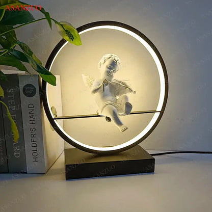 Dimmable angel table lamp featuring a white ceramic cherub playing violin in a led-lit circular frame for bedroom decor