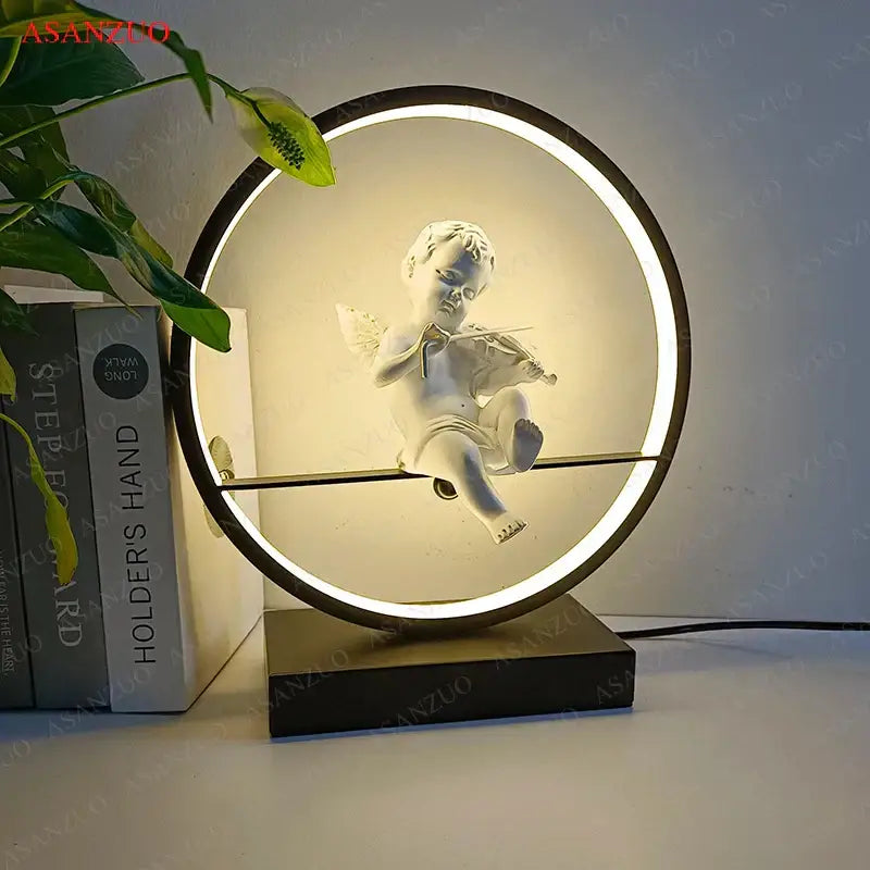 Dimmable angel table lamp featuring a white ceramic cherub playing violin in a led-lit circular frame for bedroom decor