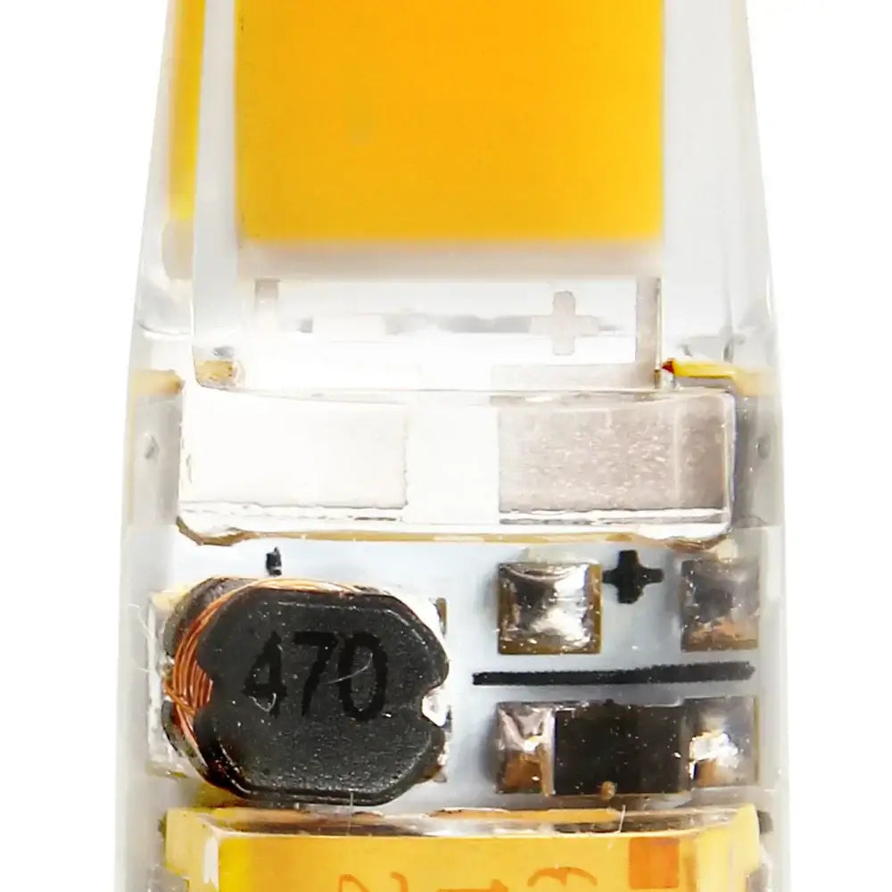 Clear plastic housing of dimmable g4 led bulb with yellow tip showing led chip and black inductor for living room lights