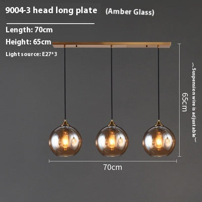 Amber glass pendant light with three spherical bulbs and a wooden plate, 70cm long.