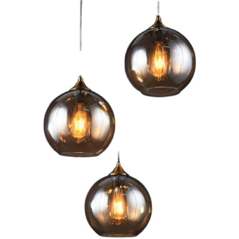 Smoked glass pendant light with brass accents, modern design.