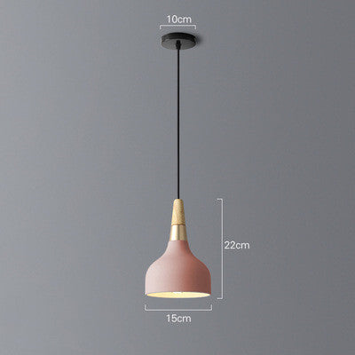 Pink pendant light with gold accents, black cord and metal base.