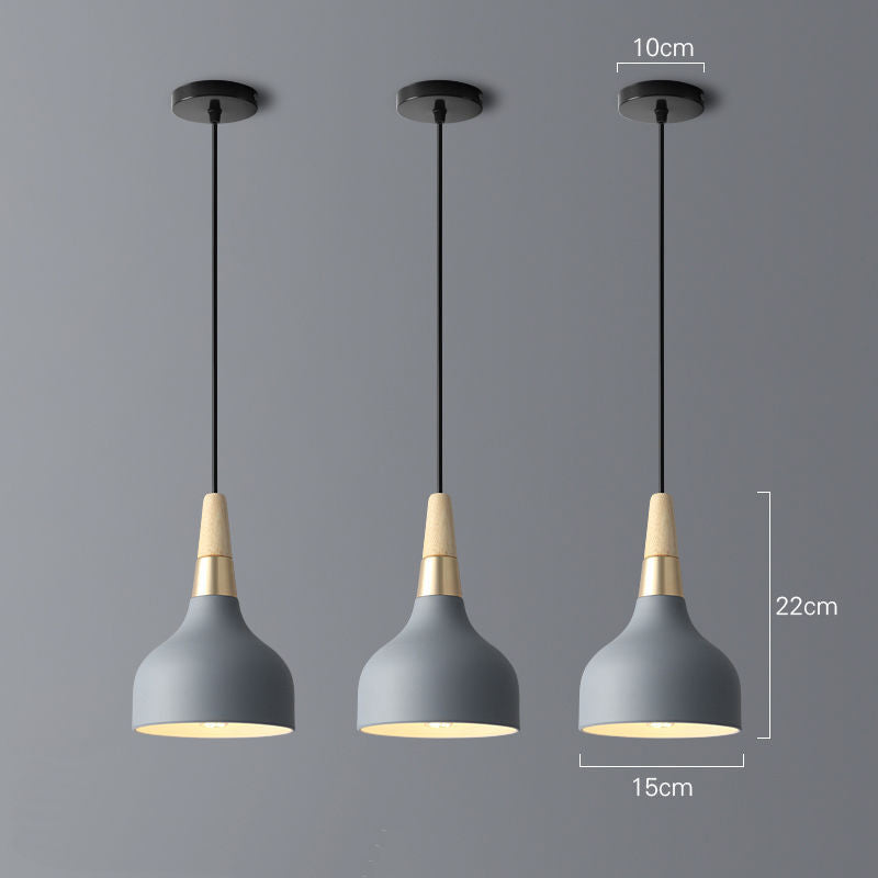 Gray concrete pendant light with brass accents and black cord in modern design for dining room chandelier use