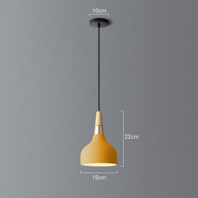 Yellow pendant light with wooden base and black cord, modern design.