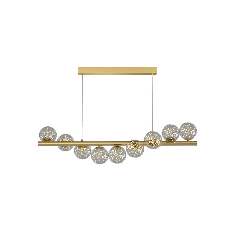 Gold linear pendant light with clear glass globe bulbs and wooden accents.