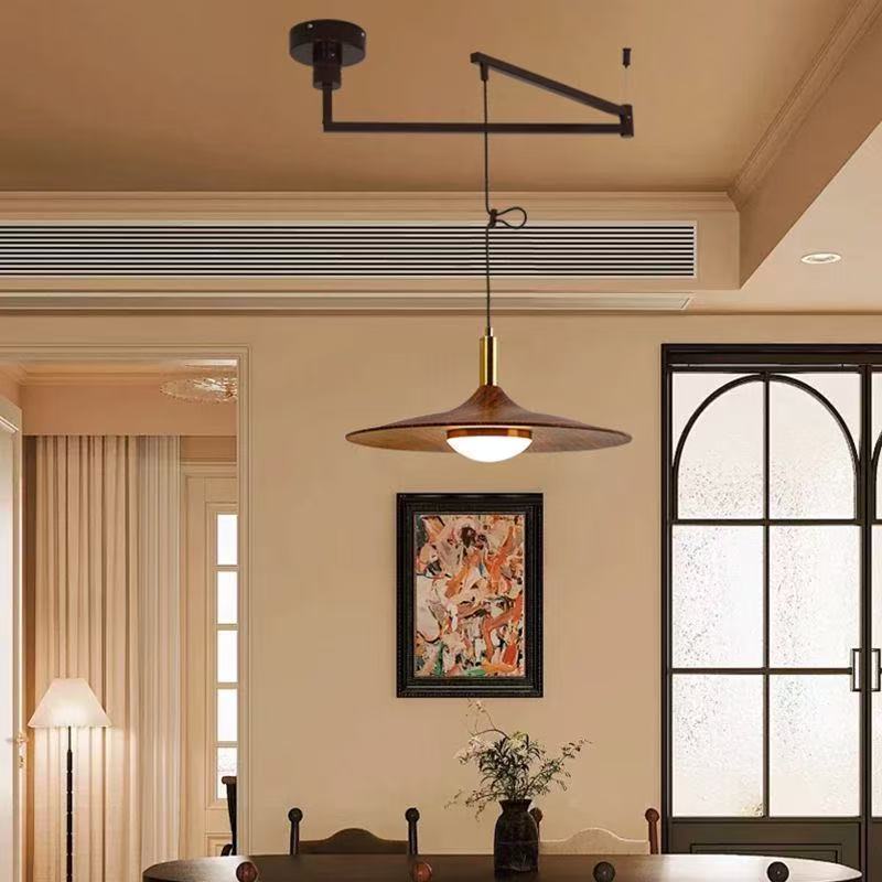 Pendant light with gold and black finish and adjustable arm in modern design for dining room chandelier walnut setting