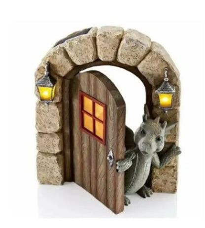 A gray dino garden sculpture features a dragon figurine peeking from a stone archway with glowing lanterns decorbites dino garden